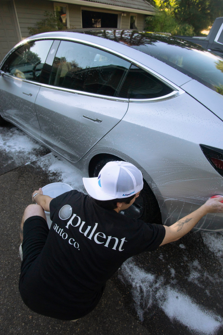 Focused hand detailing on white luxury sedan
